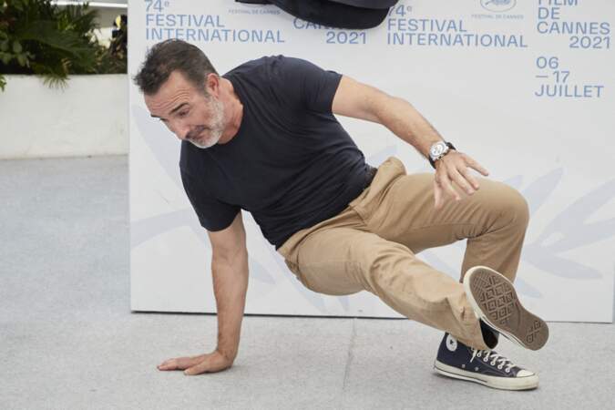 Jean Dujardin en train de faire une acrobatie au photocall du film Oss 117, le 17 juillet