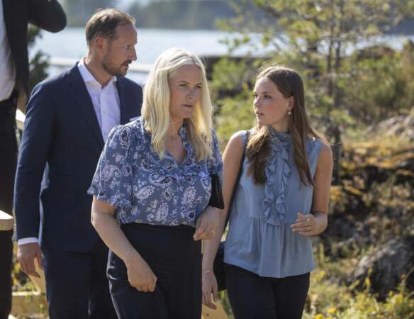  Accompagnée de sa fille,  la princesse Ingrid Alexandra de Norvège, Mette-Marit met en valeur sa chevelure blonde polaire avec un chemisier bleu électrique à Oslo, le 22 juillet 2021.

