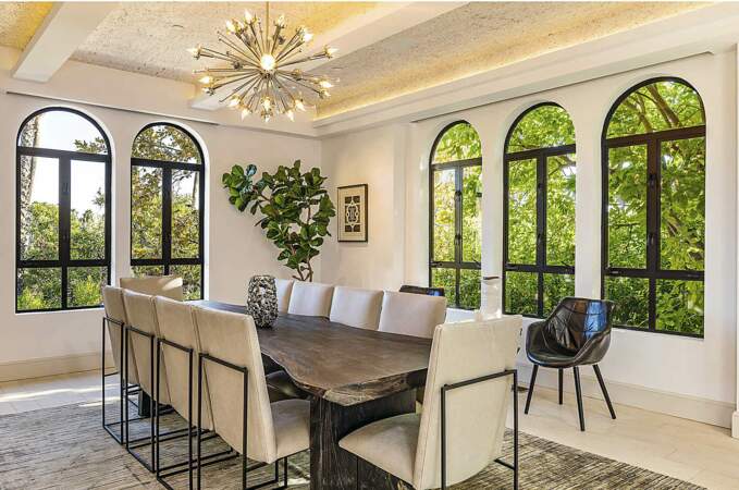 Dans un esprit méditerranéen et cosy, la salle à manger offre une vue imprenable sur les jardins luxuriants entourant la villa.