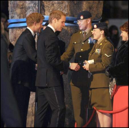 Élégants dans leur smocking, les princes Harry et William saluent les soldats britanniques présents pour la première mondiale du film "Quantum of Solace", le 29 octobre 2008, à Londres.