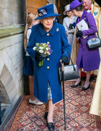 La reine Elizabeth II avec son bouquet de fleurs et sa canne pour l'aider à marcher à la sortie de l'abbaye de Westminster, à Londres, le 12 octobre 2021.