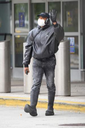 Kanye West portant un masque sanitaire salue ses fans depuis l'entée de l'aéroport JFK de New York, ce mardi 19 octobre 2021.