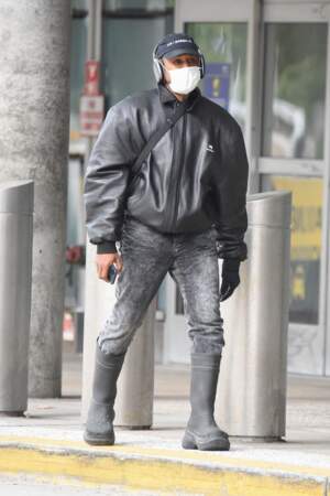 Kanye West porte un masque sanitaire traditionnel après avoir surpris la foule avec son visage caché sous un masque au style chirurgical, à l'aéroport JFK de New York, ce mardi 19 octobre 2021.