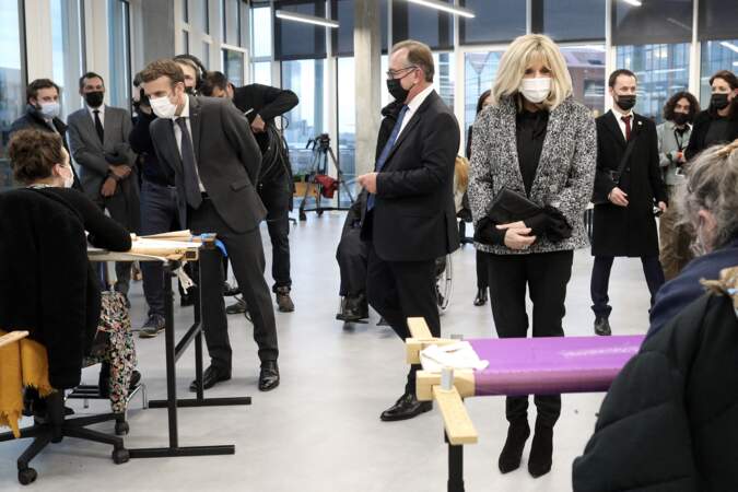 Brigitte Macron porte une tenue Chanel Haute Couture, tout en noir sauf la fameuse veste en tweed emblématique.