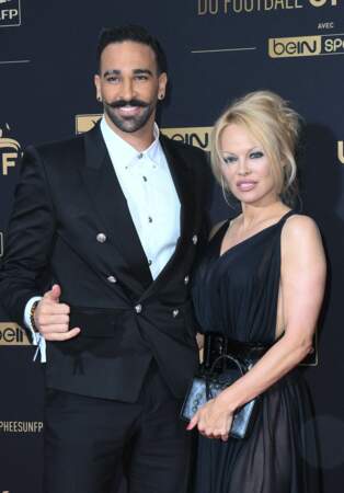 Adil Rami : Pamela Anderson fréquente le footballeur français en 2017. Ils se séparent en 2019 après que l'actrice l'accuse de violence et de mener une double vie