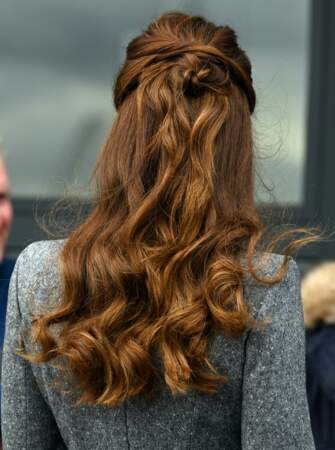 Kate Middleton soigne l'attache de sa demi-queue de cheval, avec un joli effet macaron, le 3 février 2022.