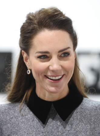 Kate Middleton tout sourire avec sa robe col Claudine, sa demie-queue de cheval et les bijoux de la princesse Diana