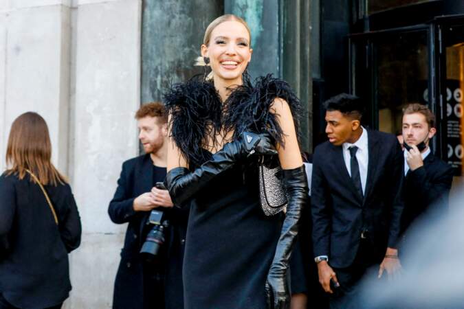 Leonie Hanne sublime dans une robe noir avec des détails plumes sur les épaules pour assister au défile Elie Saab