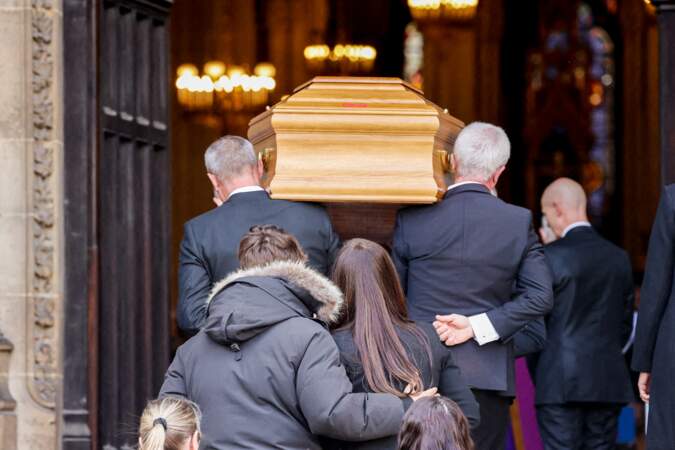 Soutenue par son fils Tom Pernaut, Nathalie Marquay suit l'entrée du cercueil dans la basilique Sainte-Clotilde, à Paris, le 9 mars 2022.