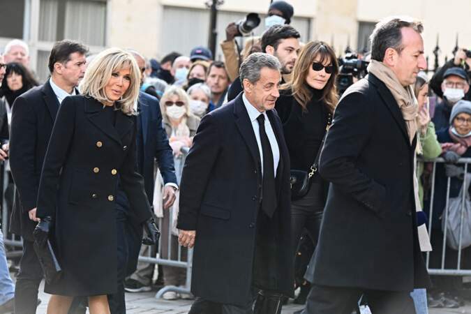 La première dame Brigitte Macron, l'ancien président de la République Nicolas Sarkozy et son épouse Carla Bruni arrivent aux obsèques de Jean-Pierre Pernaut en la Basilique Sainte-Clotilde à Paris le 9 mars 2022.