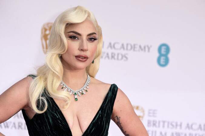 Lady Gaga est arrivée à la cérémonie des BAFTA 2022 avec une coiffure crantée façon Jessica Rabbit. Il s'agit de boucles plaquées, une coiffure très populaire des années 20. Le 13 mars 2022.