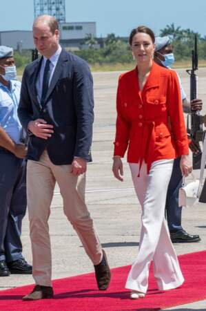 Kate Middleton quitte le Belize en pantalon large blanc et veste orangée Yves Saint Laurent vintage