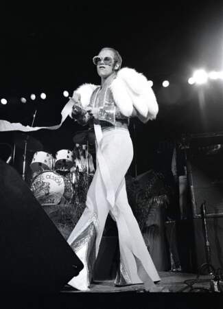 Elton John, dans un costume à pattes d'eph et veste bolero en fourrure, en 1974