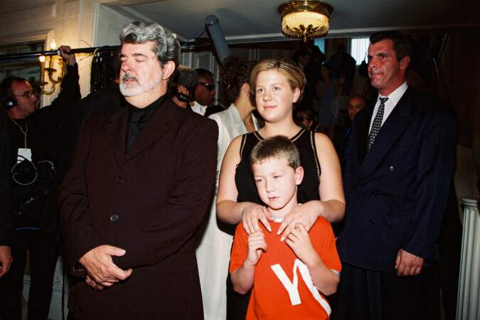 George Lucas, avec deux de ses enfants, lors de la collection Versace de Haute Couture Automne Hiver 1999-2000, en France, en 1999.