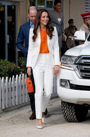 Kate Middleton porte un costume blanc signée Alexander Mcqueen associé d'accessoires oranges lors de son deuxième jour en Jamaïque, le 23 mars 2022