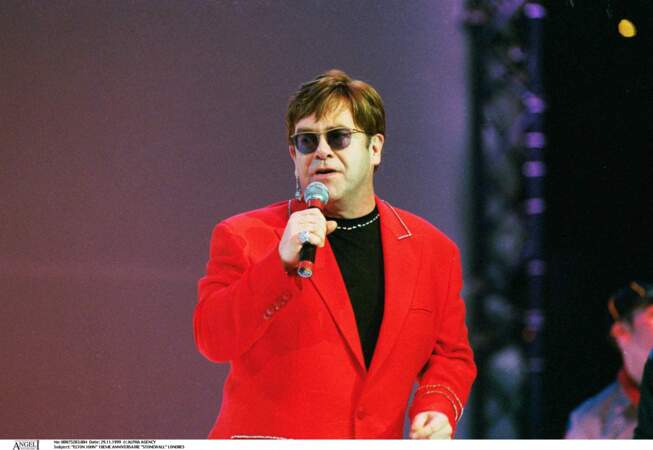 Elton John en blazer rouge signature lors d'un concert à Londres
