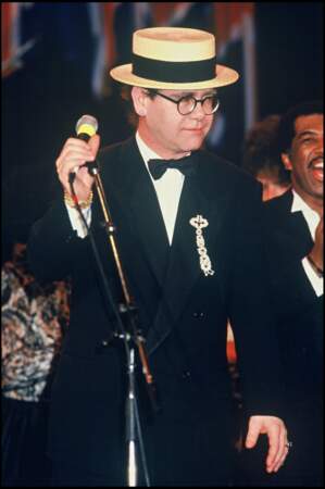 Elton John en 1988, dans une tenue sobre et élégante en concert, il adopte les chapeaux pour dissimuler sa perte de cheveux
