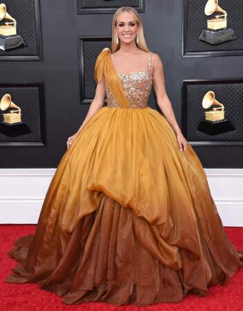 Carrie Underwood est dans une robe de princesse jaune moutarde et pailletée de la marque Dolce Gabbana à la 64ème édition des Grammy Awards. Las Vegas le 3 avril 2022.