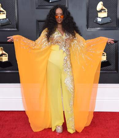 H.E.R brille dans une robe jaune à paillettes de la marque  Dundas World à la 64ème édition des Grammy Awards. Las Vegas le 3 avril 2022.