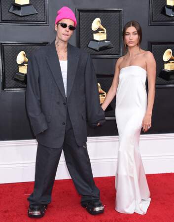 Justin Bieber est habillé d'un ensemble de costume XXL signé Balenciaga et sa femme, Hailey Rhode Bieber d'une sublime robe en satin ivoire Yves Saint Laurent à la 64ème édition des Grammy Awards. Las Vegas le 3 avril 2022.