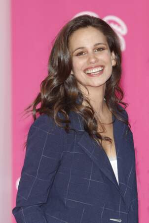 Lucie Lucas rayonne en blazer court bleu marine à carreaux pour présenter la nouvelle série "Cannes Confidential" dans laquelle elle joue. 