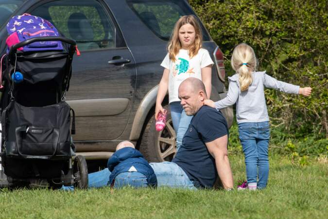 Mike Tindall, posé dans l'herbe avec ses trois enfants, le 14 avril 2022.