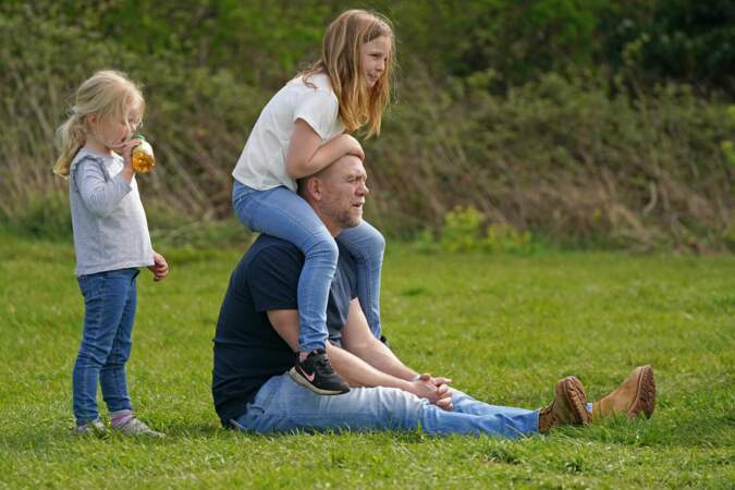 Mike Tindall, posé dans l'herbe en compagnie de ses trois enfants, le 14 avril 2022.