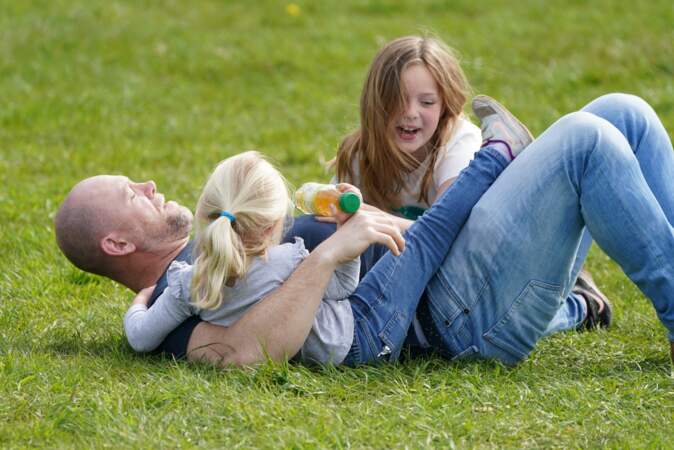 Mike Tindall, jouant dans l'herbe avec ses trois enfants, le 14 avril 2022.