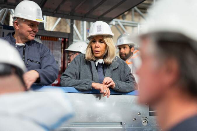Brigitte Macron discutant avec les artisans travaillant sur le chantier de restauration de  Notre-Dame de Paris