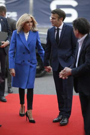 En manteau bleu électrique, Brigitte Macron arrive main dans la main avec son époux Emmanuel Macron, lors du débat de l'entre-deux-tours, mercredi 20 avril 2022.  