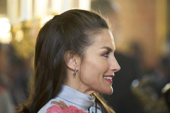 La reine Letizia d'Espagne enroule délicatement une mèche de cheveux à sa demi-queue de cheval, le 21 avril 2022. 