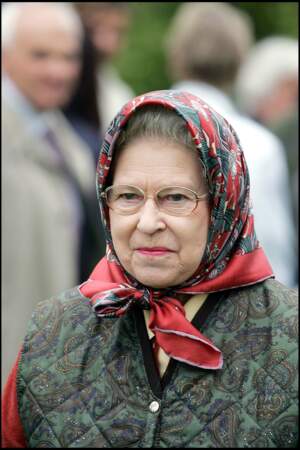 la reine Elizabeth II a complété sa doudoune sans manche à l'imprimé paisley avec un foulard fleuri, lors de sa venue au traditionnel Royal Windsor Horse Show, le 13 mai 2006.