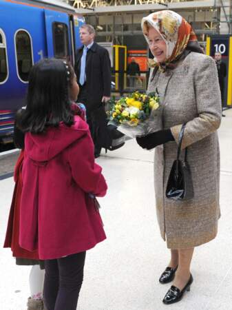 La reine Elizabeth II très élégante dans un manteau long en tweed assorti à son foulard orangé, lors de l'inauguration de la ligne de chemin de fer, à Norfolk, le 17 décembre 2009.