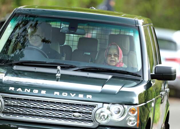 Pour effectuer son déplacement en voiture, la reine Elizabeth II a misé sur son combo préféré : lunettes de soleil et foulard noué sur la tête, le 25 avril 2022.
