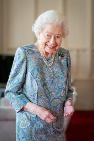 La reine Elizabeth II a pris le soin d'accessoiriser sa robe fleurie avec un double collier de perles blanches, le 28 avril 2022.