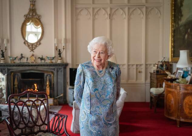 La reine Elizabeth II très coquette dans une robe en soie bleue et grise à motifs fleuris lors de sa rencontre avec le président de la Confédération suisse Ignazio Cassis au Palais de Buckingham, le 28 avril 2022.