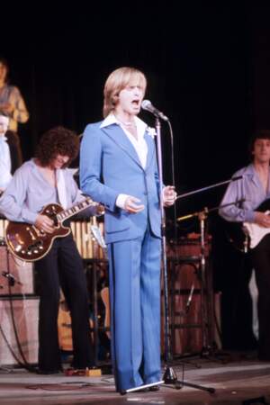 Dave en dandy-chic dans un costume bleu ciel assorti à une chemise blanche au large col italien, sur la scène de l'Olympia en avril 1977. 