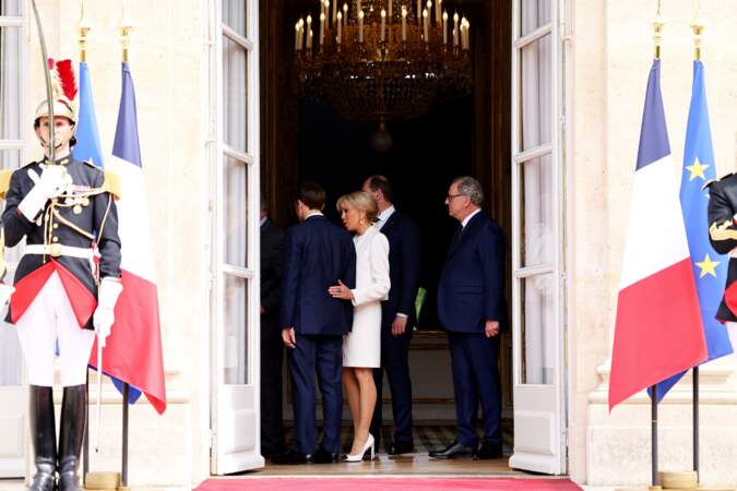 Brigitte Macron a également porté un manteau court de type cardigan de la même teinte qu’elle n’a pas quitté de toute la cérémonie.