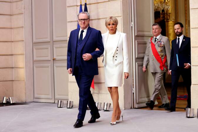 Monochrome assumé jusqu'au bout des ongles, Brigitte Macron porte des escarpins blanc assortis au reste de la tenue