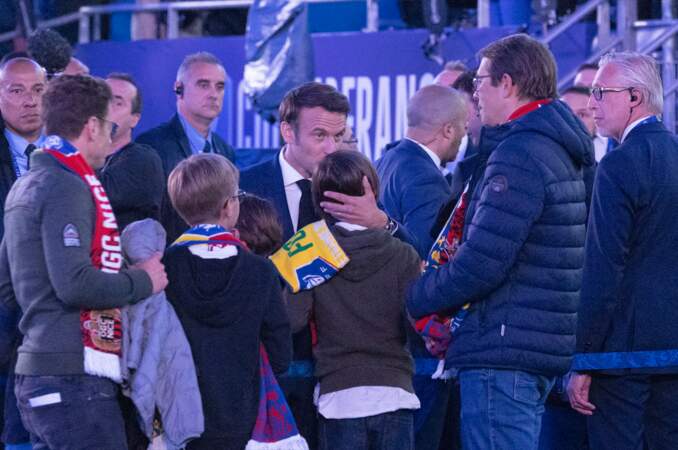 Emmanuel Macron embrassant un des petits-fils de son épouse lors de la finale de la Coupe de France de football entre le FC Nantes et l'OGC Nice, le 7 mai 2022