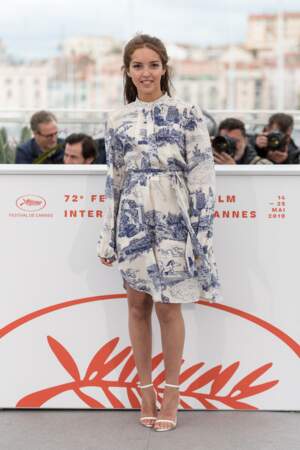 Lyna Khoudri enfile une fine paire de sandales blanches lors du 72ème Festival de Cannes, le 17 mai 2019. 