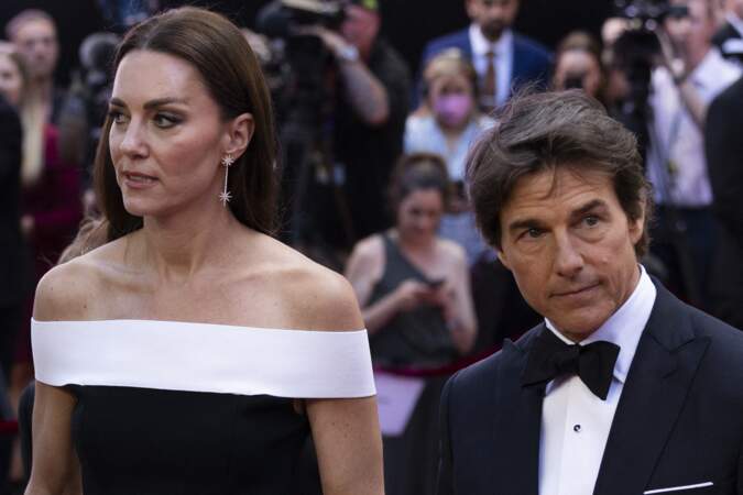 Kate Middleton pose avec Tom Cruise dans une longue robe moulante très ajustée et dévoilant ses épaules signée Roland Mouret, un créateur français que Meghan Markle adore, le 19 mai 2022.