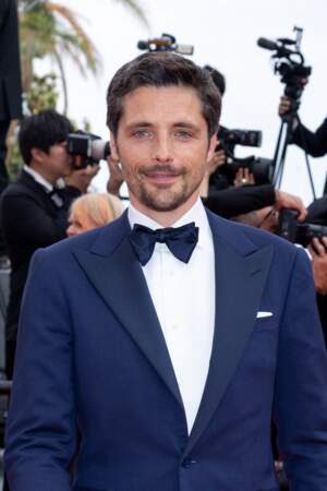 Raphaël Personnaz très chic dans un costume bleu nuit assorti à son nœud papillon pour la montée des marches du film Decision to Leave, lors du 75ème Festival International du Film de Cannes, le 23 mai 2022.