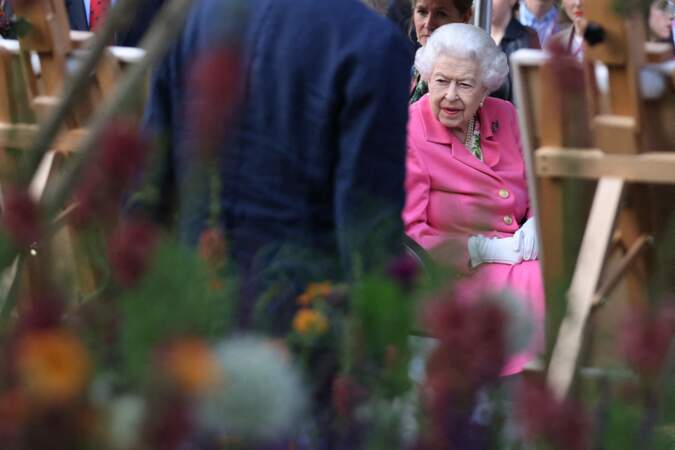 Elizabeth II très intéressée par ce qui lui est présenté à l'exposition florale "RHS Chelsea Flower Show" au Royal Hospital à Londres, le 23 mai 2022.
