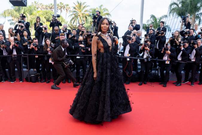 Naomi Campbell à couper le souffle dans une robe noire sertie de plumes signée Valentino pour la montée des marches du film Decision to Leave, lors du 75ème Festival International du Film de Cannes, le 23 mai 2022.