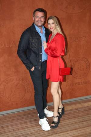 Arnaud Ducret en total look jean et sa femme Claire en sandales compensées Yves Saint Laurent au village de Roland Garros, le 23 mai 2022. 