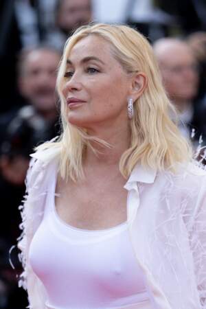 En chemise longue sertie de plumes et pantalon large, Emmanuelle Béart a envoûté le tapis rouge lors du 75ème Festival International du Film de Cannes, le 25 mai 2022.