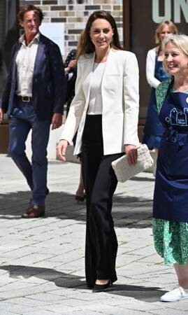 En pantalon fluide noir, top et blazer crème... Kate Middleton a le sourire pour rencontrer des bénévoles le 8 juin 2022.