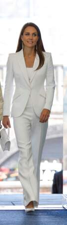 Kate Middleton est vêtue d'une veste de blazer Alexander McQueen qu'elle boutonne, le 22 juin 2022.  