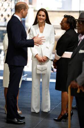 Kate Middleton se glisse dans un costume blanc Alexander McQueen pour célébrer le Windrush Day, le 22 juin 2022. Elle accessoirise son look d'un mini sac Mulberry. 
